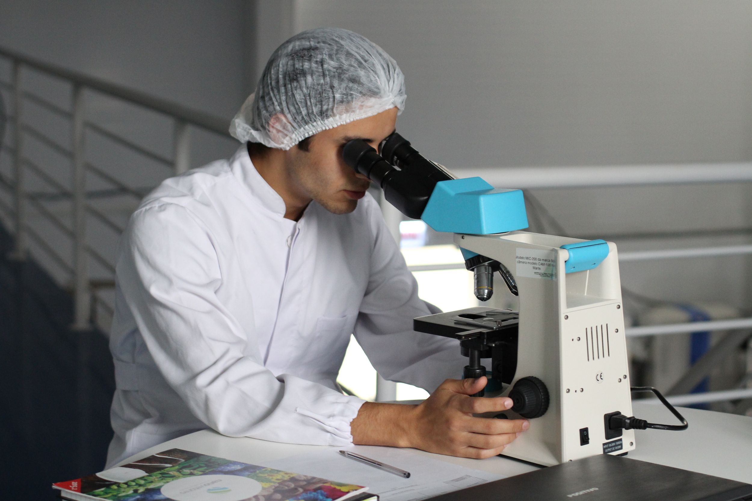 Researcher examining something in a microscope.